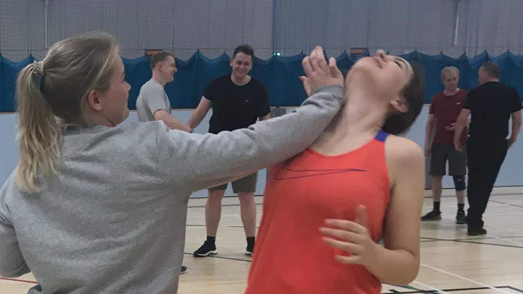 a woman hitting another woman in the jaw with her palm