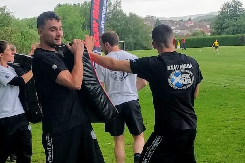 man punching a pad that another man is holding